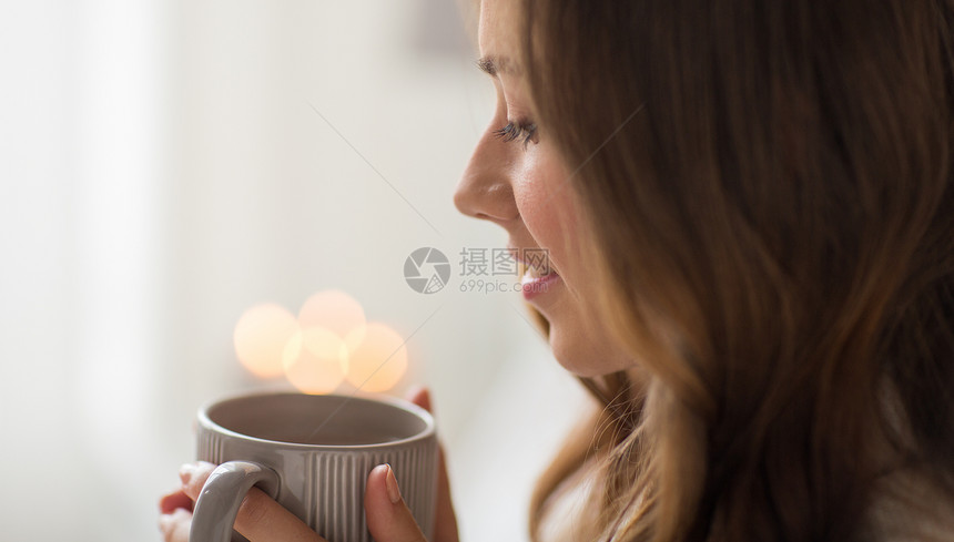 饮料,诞节潮湿的快乐的女人与灯光杯咖啡茶家里家喝杯咖啡的快乐女人图片