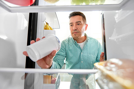 食物饮食饮食中男子厨房的冰箱里酸奶男人厨房的冰箱里食物图片