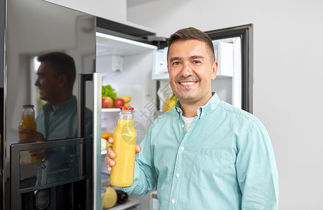 健康饮食,食物饮食中男子冰箱家里厨房瓶橙汁男人家里厨房的冰箱里果汁图片