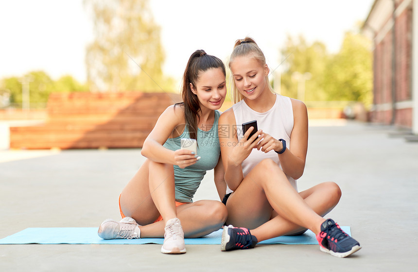 健身,运动健康的生活方式微笑的轻妇女女朋友与智能手机屋顶感的女人朋友屋顶上智能手机图片