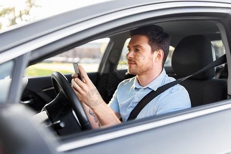运输,车辆技术微笑的人司机驾驶汽车用智能手机开车用智能手机的人图片