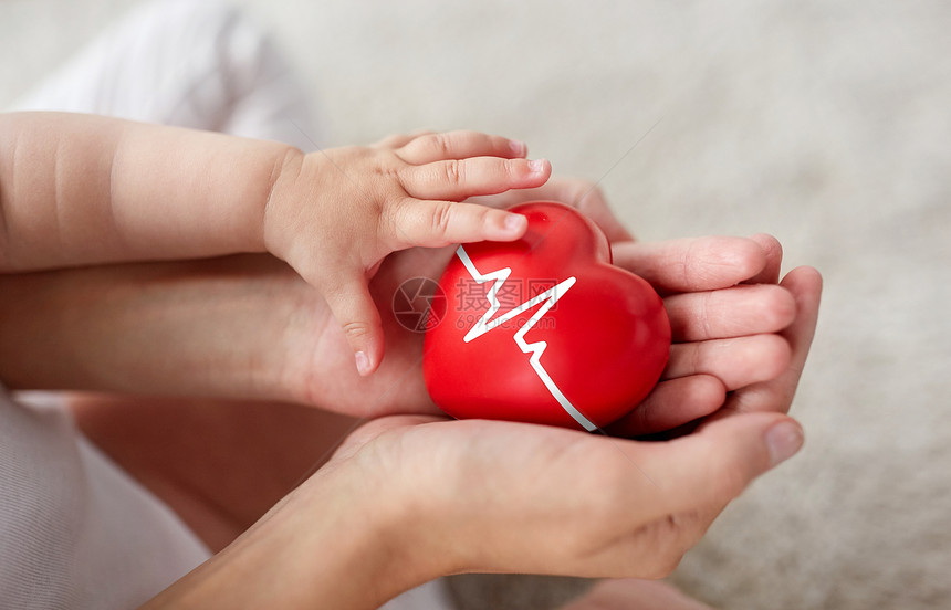 家庭慈善健康理念亲密的小婴儿母亲的手握着红色的心与心电图线婴儿母亲抱着红色的心与心电图线图片