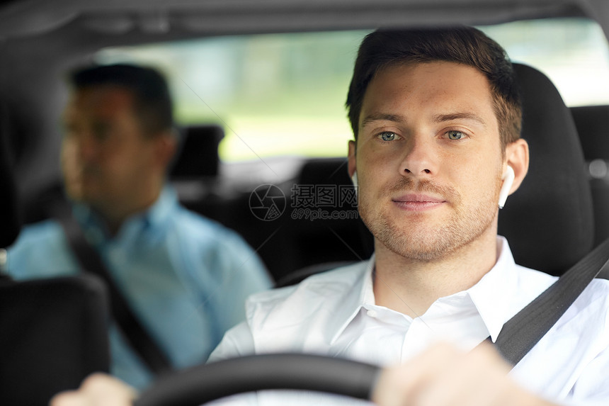 运输,出租车人的男司机与无线耳机无手设备驾驶汽车与乘客男司机带无线耳机驾驶汽车图片