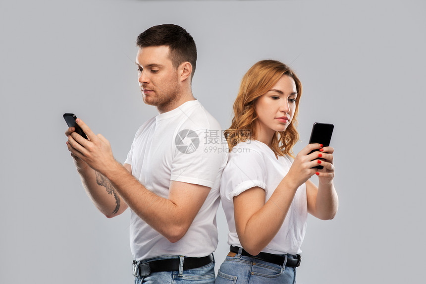 技术,关系人的白色T恤与智能手机灰色背景穿着白色T恤智能手机的夫妇图片