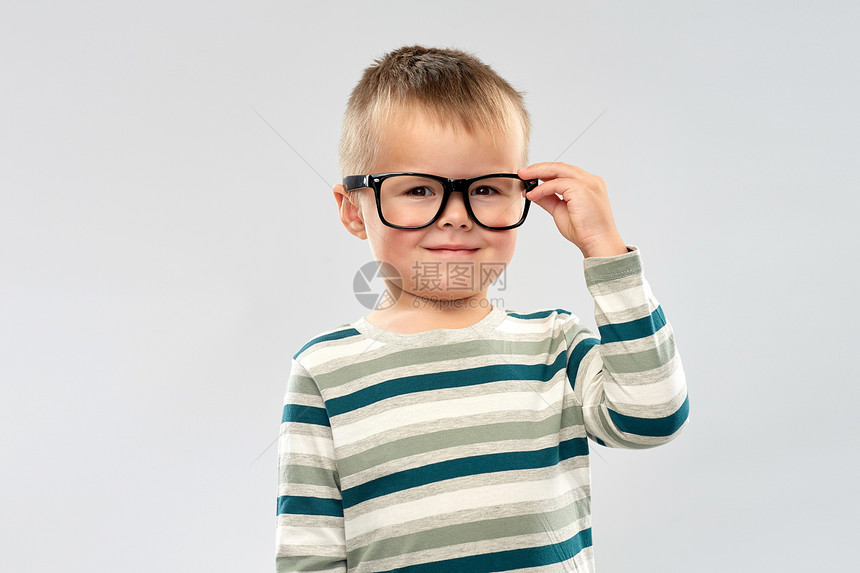 学校,教育视觉微笑的小男孩灰色背景小男孩的肖像戴眼镜的微笑男孩的肖像图片