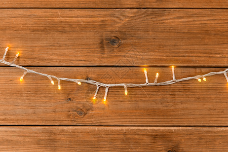 诞节,假日照明木制背景上的电动花环灯木制背景上的诞花环灯图片