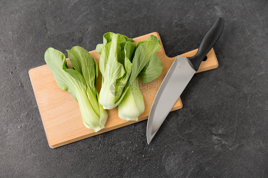 蔬菜,食物烹饪Bokchoy大白菜菜刀木制切割板上的石板石背景白菜切板上的刀图片