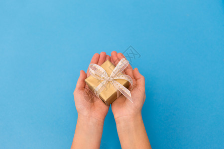 节日,礼物问候手着蓝色背景的小诞礼盒手着小诞礼盒图片