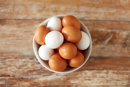 食物,烹饪烹饪天然鸡蛋陶瓷碗木制桌子上把鸡蛋放木制桌子上的陶瓷碗里背景图片