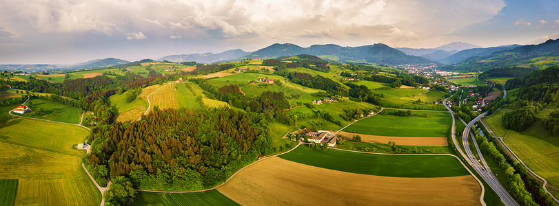 奥地利的春季旅行阿尔卑斯山脉的绿色田野草地高山乡村的道路交叉口图片