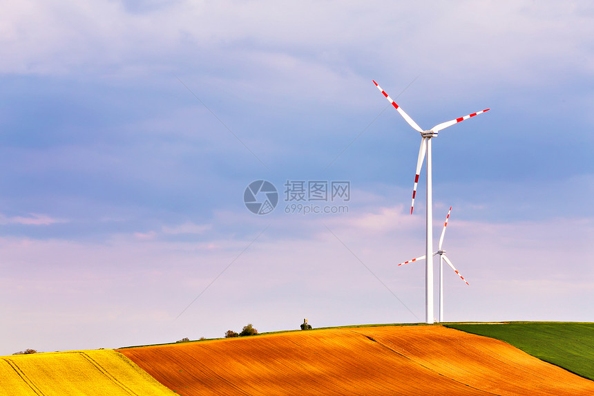 春天阳光明媚,绿色的田野里风力发电机生态动力风力涡轮机公园发电山顶上的狩猎箱下奥地利,靠近珀斯多夫图片