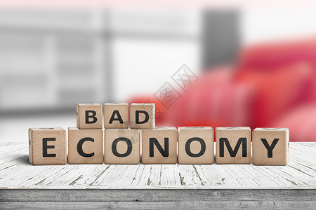 糟糕的经济标志办公室的木桌上,背景红色图片