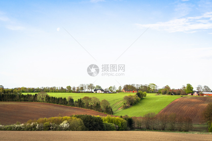 乡村景观与耕地下的蓝天春天与农场的背景图片