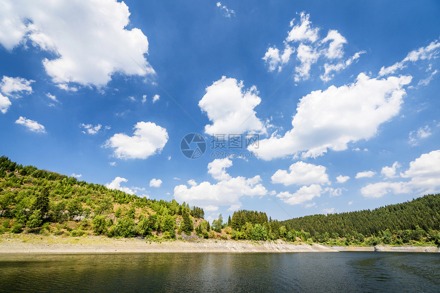 夏天,蓝天下,绿树围绕着湖图片