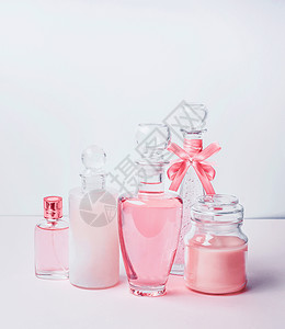 各种粉红色化妆品瓶花站白色粉红色背景上与克护肤,化妆品店,销售抽象美容图片