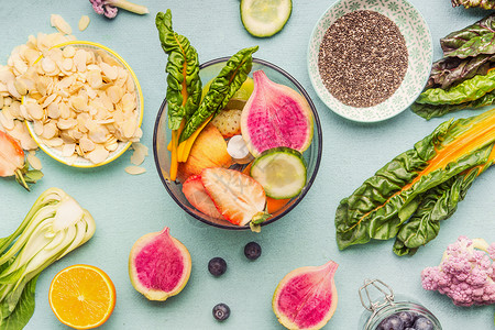 健康冰沙纯素成分水果,浆果,杏仁辣椒种子搅拌机上的轻桌,顶部视图图片