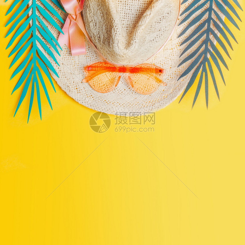 带橙色太阳镜的草帽黄色背景的热带树叶,俯视图暑假热带度假平躺图片