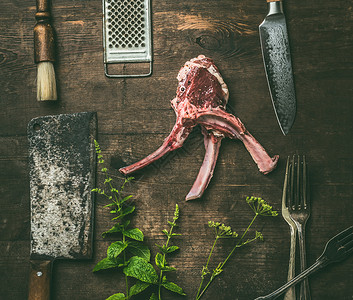生羊肉排骨与新鲜草药厨房用具乡村木制背景,顶部视图肉烧烤烧烤准备羊肉架图片