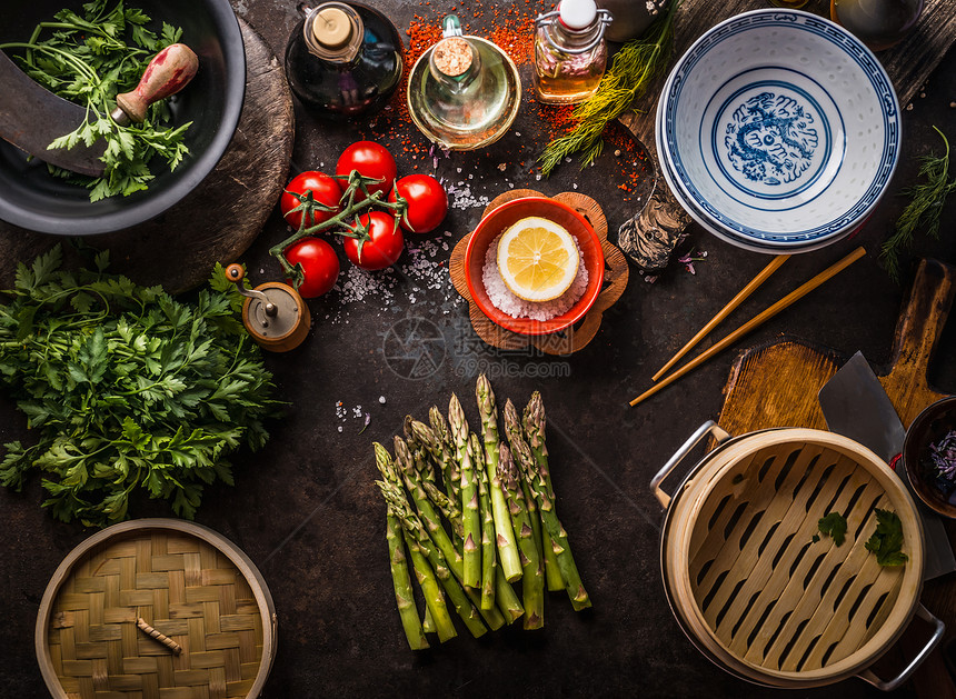 绿色芦笋串,亚洲竹笼新鲜美味的成分,健康的素食饮食烹饪亚洲风格的乡村餐桌与筷子空碗,顶部景观图片