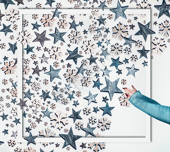 创意蓝色框架寒假的女人手针毛衣,蓝色的星星装饰雪花图案成的框架白色的背景创意诞布局顶部视图平躺背景