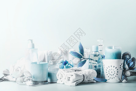美丽的蓝白色水疗构图各种化妆品与燃烧蜡烛花桌子上的轻背景护肤现代美的图片