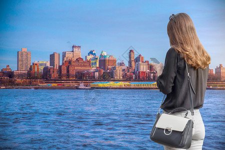 俯视纽约市灰度个女人看着海滨的电话,俯瞰曼哈顿美国背景
