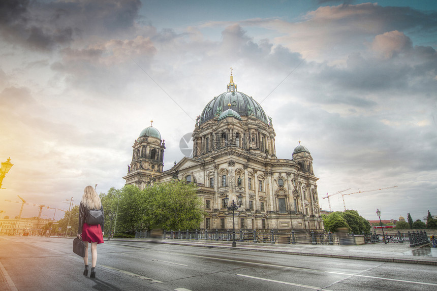 位穿着红色裙子的女人沿着柏林大教堂附近的大街走着德国图片