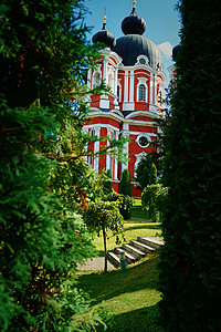 高大的东正教教堂,树巷蓝天下的绿色花园图片