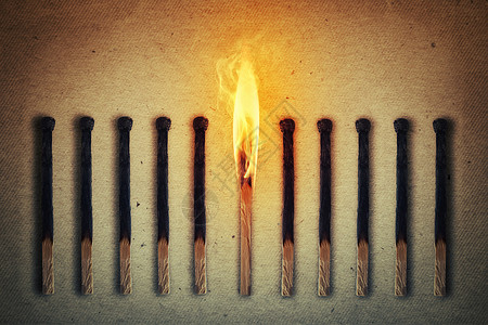燃烧的火柴站中间排熄灭的,烧焦的火柴领导理念背景图片