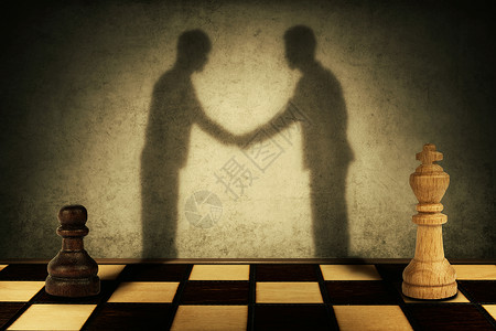典当棋子棋子国王站前,他们的影子变成了商人握手商业等级水平平背景