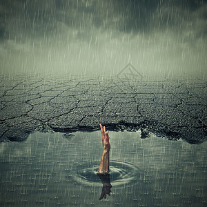 雨坑超现实主义的形象,只手溺水的人个坑坑洼洼的沥青中寻求帮助个想象中的城镇里,条脏水坑的破路背景
