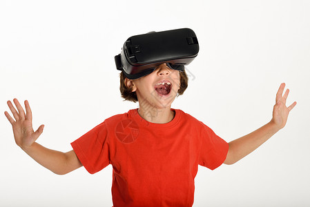 小女孩戴着虚拟现实眼镜,用手手势快乐惊奇的孩子戴着虚拟现实眼镜看电影玩电子游戏,隔离白色背景下背景图片