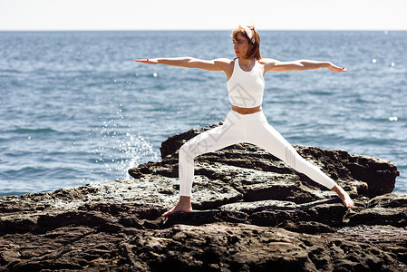 轻的女人海滩上瑜伽女穿着白色运动服图片