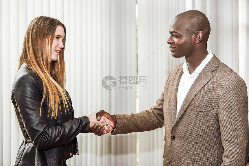 黑人商人办公室里位穿着西装的金发女子办公室握手图片
