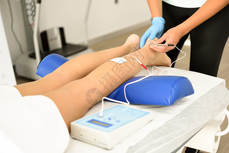 电针干针女踝关节电针干针连接机由针灸师用于女患者针刺,由EPI内经皮电钻引导理疗中心名轻女子踝关节物理治疗中干的高清图片素材