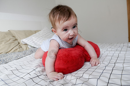 快乐的女婴,五个月大,床上图片