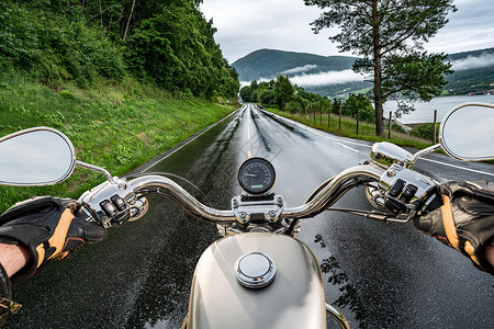 摩托车手雨中骑摩托车人称视图背景图片