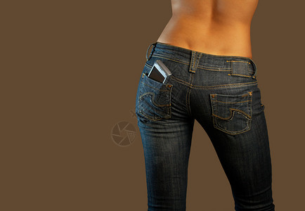 牛仔裤想象交流穿牛仔裤的女孩的底部,口袋里手机背景图片