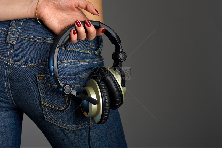 穿着牛仔裤的女背部,手着耳机音乐迷图片