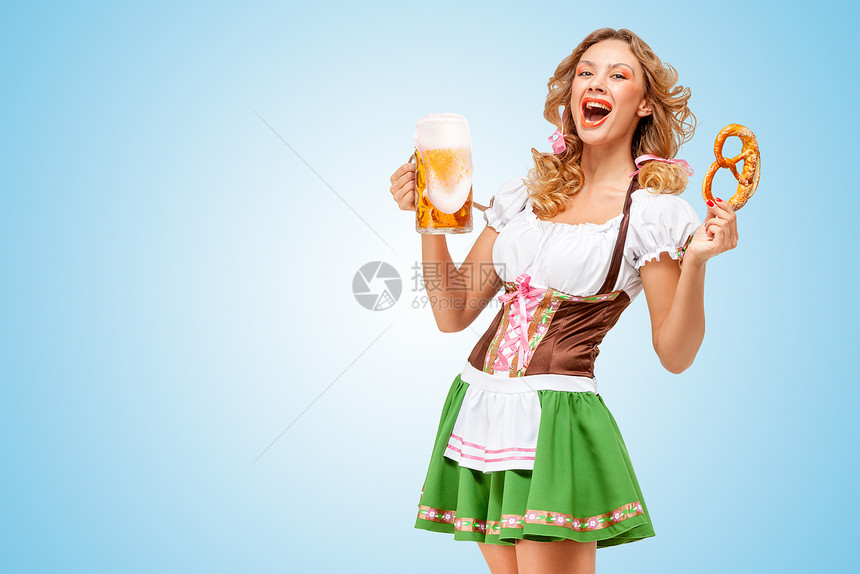 轻感的啤酒节女服务员穿着传统的巴伐利亚连衣裙,蓝色背景上提供椒盐卷饼啤酒杯图片