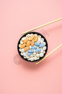 创意照片的药丸安排为寿司粉红色背景图片