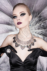 时尚工作室照片美丽优雅的女人与明亮的化妆珠宝时尚箭头形状戴着戒指耳环的项链的女人迷人的盖茨比风格背景图片