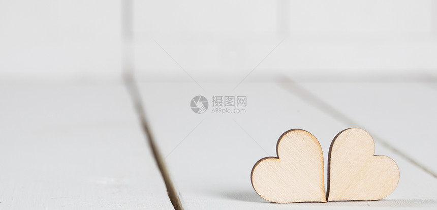 情人节的心两颗木制的情人节心白色的木制背景上图片