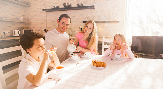 家人厨房吃早餐家人微笑着阳光明媚的日子里厨房吃早餐图片