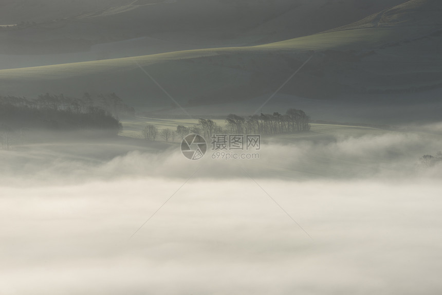 美丽的雾状英国乡村景观日出冬天,层层滚动田野图片