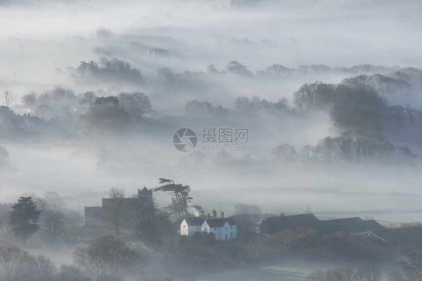 美丽的雾状英国乡村景观日出冬天,层层滚动田野图片