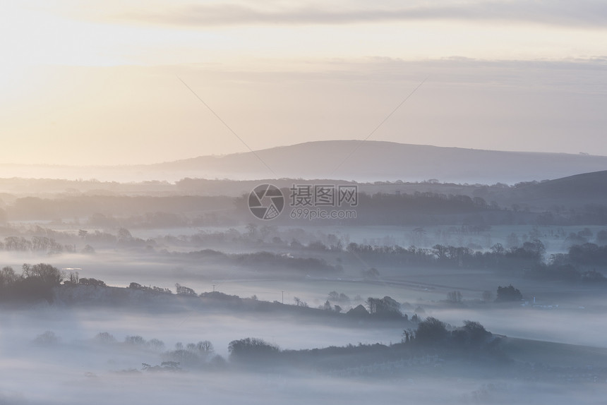 令人惊叹的雾状英国乡村景观日出冬季美丽的雾状英国乡村景观日出冬天,层层滚动田野图片