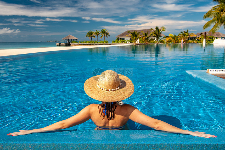 马尔代夫海滩游泳池戴帽子的女人马尔代夫海滩泳池里戴着太阳帽的女人图片