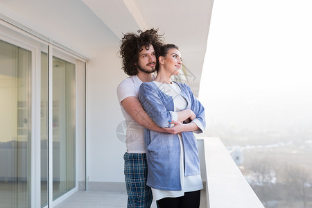 相爱的夫妇家里的阳台上拥抱,分享情感幸福背景图片