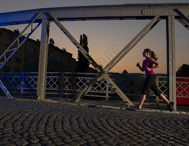 城市运动,轻健康的女人城市的清晨慢跑过桥图片